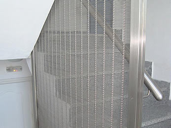 Media <d>meta</d>l mesh is installed as the balustrade infill of a stair.